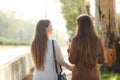 Back view of two women walking and talking in a park