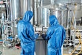 Back view of two workers using control panel at chemical factory Royalty Free Stock Photo