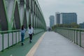 Back view of two young women on their rental electric scooters on a bridge in Bratislava on their daily commute in cloudy weather Royalty Free Stock Photo