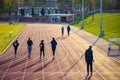 Back view of unidentified people running at the Parliament Hill athletics track in London