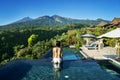 Unknown woman relaxes on pool with mount view Royalty Free Stock Photo