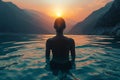 Back View of Unrecognizable Female Silhouette Standing in Rippling Sea Water Enjoying Sunset Over Mountains Royalty Free Stock Photo