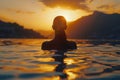 Back View of Unrecognizable Female Silhouette Standing in Rippling Sea Water Enjoying Sunset Over Mountains Royalty Free Stock Photo