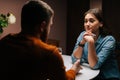 Back view unrecognizable loving young man making proposal for marriage to calm pretty woman sitting at table with Royalty Free Stock Photo