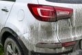 Back view of a very dirty car. Fragment of a dirty SUV. Dirty headlights, wheel and bumper of the off-road car with swamp splashes Royalty Free Stock Photo