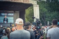 Back view video operator wear cap operating camcorder at live Memorial March event in Dallas