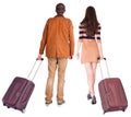 Back view of walking couple with suitcase.