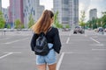 Back view of walking fashionable teenage girl with backpack Royalty Free Stock Photo