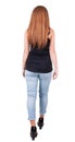 Back view of walking woman. beautiful redhead girl in motion. Royalty Free Stock Photo