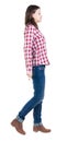 Back view of walking woman in checkered shirt. Royalty Free Stock Photo