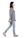 Back view of walking woman in jeans .