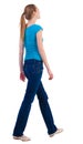 Back view of walking woman in jeans and shirt. Royalty Free Stock Photo