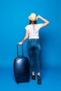 Back view of walking woman with suitcase. beautiful girl in motion. backside view of traveler with baggage Isolated over blue back