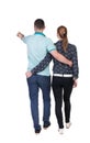 Back view of walking young couple (man and woman) pointing. Royalty Free Stock Photo