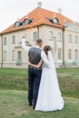 Young man groom embracing young wonderful woman bride, raising hands with glasses of wine. Relationship, celebration. Royalty Free Stock Photo