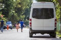 Back view white passenger medium size commercial luxury minibus van parked on summer city street. Royalty Free Stock Photo