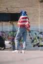 back view of woman with american flag in hands standing on street, 4th july Royalty Free Stock Photo
