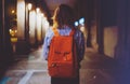 Back view woman with backpack on background bokeh light in night atmospheric city, blogger hipster planing holiday travel, mockup