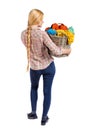 Back view of woman with basket dirty laundry. girl is engaged in washing. Royalty Free Stock Photo