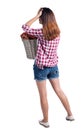 Back view of woman with basket of dirty laundry. girl is engaged in washing. Royalty Free Stock Photo