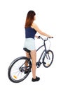 Back view of a woman with a bicycle. cyclist sits on the bike.