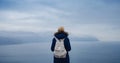 Back view of woman on shore of North sea on cold winter day. Royalty Free Stock Photo