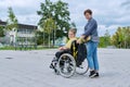 Back view of woman with boy in wheelchair near school building