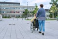 Back view of woman with boy in wheelchair near school building