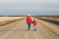 Woman and child walking down a dirt road Royalty Free Stock Photo