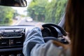 Back view of a woman driving car for summer road trip travel. Driver hand holding steering wheel for control car. Safe driving Royalty Free Stock Photo