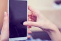 Back view of a woman hands using smart phone with blank screen close up. White phone with a black screen in the hands of Royalty Free Stock Photo