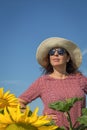 Back view of woman in hat looking at sunflower Royalty Free Stock Photo