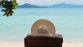 Back view of woman in hat lying on beach chair at tropical resort Royalty Free Stock Photo