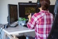 Back View Woman in a headset with Xbox controller playing video games on her desktop pc. Online time, virtual life Royalty Free Stock Photo