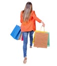 Back view of a woman jumping with shopping bags. Royalty Free Stock Photo