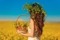 Back view of woman with long healthy hair over Yellow rape field landscape background. Attracive brunette girl with blowing