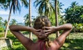 Woman looking at beautiful tropical view with palm trees and small pond Royalty Free Stock Photo