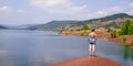 Back view woman looking red coast lake deposits clay sediments on Lac Salagou in southern France