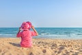Back view woman with pink straw sun hat sitting alone relax enjoying on the beach look in the sea Royalty Free Stock Photo