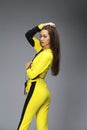 Portrait of a young beautiful brunette woman in yellow tracksuit Royalty Free Stock Photo