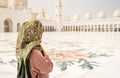 Back view of Woman in The Sheikh Zayed Grand Mosque. Traditional Muslim building in the United Arab Emirates.