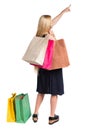 Back view of woman with shopping bags pointing . Royalty Free Stock Photo