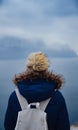 Back view of woman on shore of North sea on cold winter day. Royalty Free Stock Photo