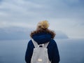 Back view of woman on shore of North sea on cold winter day. Royalty Free Stock Photo