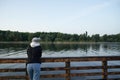 Back view of woman standing pier near lake