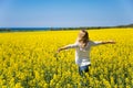 Back view of woman standing in the yellow field under blue sky. Perfect background. Royalty Free Stock Photo