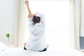 Back view of woman stretching in morning after waking up on bed Royalty Free Stock Photo