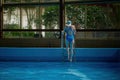Back view on woman in swimsuit getting out from pool using ladder Royalty Free Stock Photo