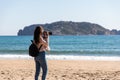 Back view of woman taking pictures with DSLR camera of islands from the beach - Medes Islands Royalty Free Stock Photo