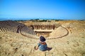 Back view of woman traveler in hat looking at amazing Amphitheater ruins in ancient Hierapolis, Pamukkale, Turkey. Grand panorama Royalty Free Stock Photo